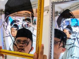 Santri menata hasil karya seni lukisan kaca wajah ulama KH. Maimun Zubair dan Gus Baha saat pameran produk UMKM pada peringatan Hari Santri Nasional (HSN) 2025 di Kabupaten Kudus, Jawa Tengah, Selasa (21/10/2025). Pameran produk UMKM yang diikuti sebanyak 72 pelaku usaha merupakan rangkaian peringatan Hari Santri Nasional serta upaya peningkatan ekonomi masyarakat, pesantren dan santri di Jawa Tengah. (Dok. Istimewa)