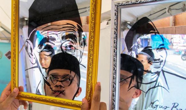 Hari Santri Nasional dan Akar Tradisi Nusantara Santri menata hasil karya seni lukisan kaca wajah ulama KH. Maimun Zubair dan Gus Baha saat pameran produk UMKM pada peringatan Hari Santri Nasional (HSN) 2025 di Kabupaten Kudus, Jawa Tengah, Selasa (21/10/2025). Pameran produk UMKM yang diikuti sebanyak 72 pelaku usaha merupakan rangkaian peringatan Hari Santri Nasional serta upaya peningkatan ekonomi masyarakat, pesantren dan santri di Jawa Tengah. (Dok. Istimewa)