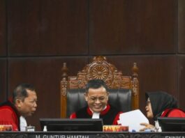 Anggota Majelis Hakim Mahkamah Konstitusi (MK) Enny Nurbaningsih (kanan), Guntur Hamzah (tengah), dan Arsul Sani (kiri) berdiskusi saat sidang pembacaan putusan uji materiil UU Polri di Gedung MK, Jakarta, Kamis (13/11/2025). MK mengabulkan uji materi terhadap pasal 28 ayat (3) UU No. 2 tahun 2002 tentang Kepolisian Negara Republik Indonesia sehingga kini anggota Polri aktif harus mengundurkan diri atau pensiun untuk menduduki jabatan di luar kepolisian. (Dok. Istimewa)